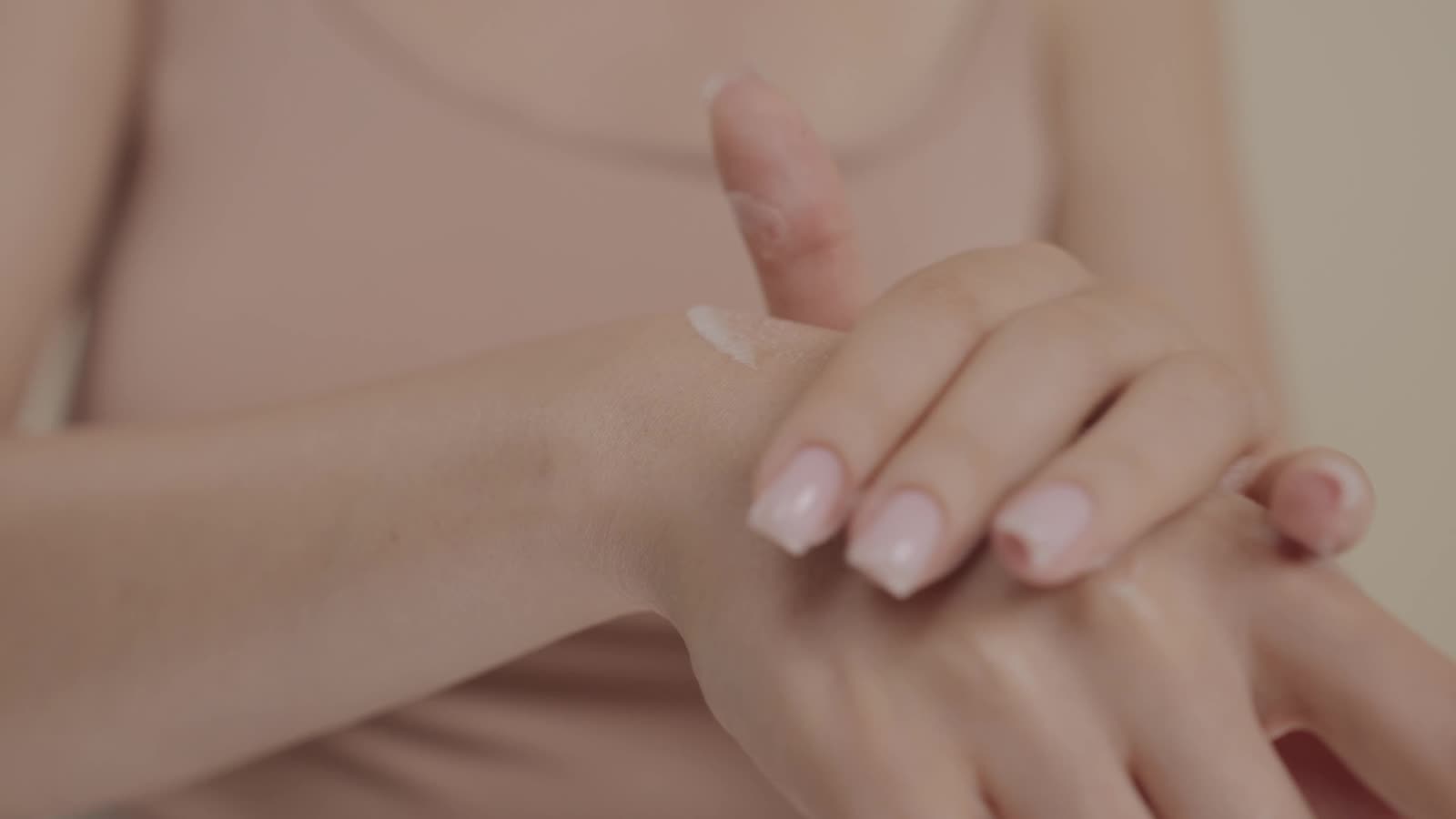 Hands pressing cream into skin