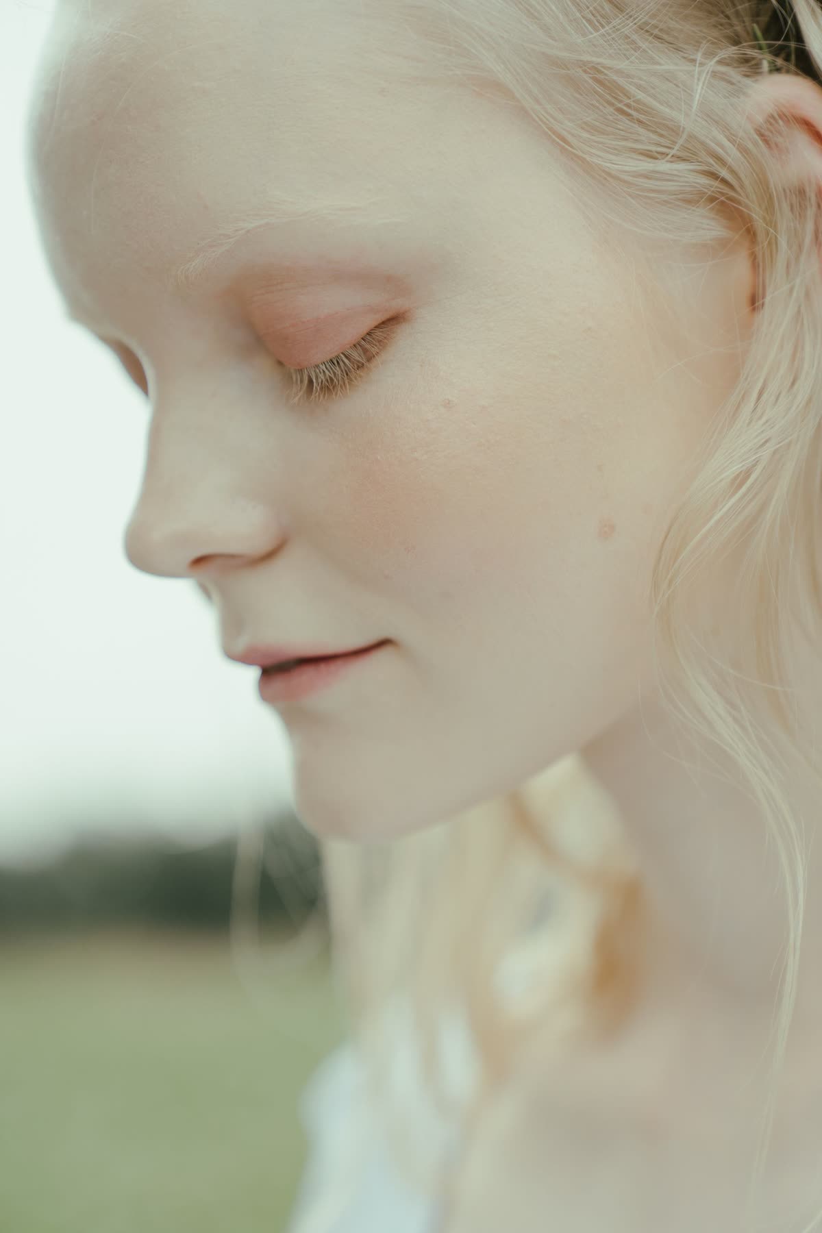 Portrait of a woman with luminous, porcelain skin, eyes closed